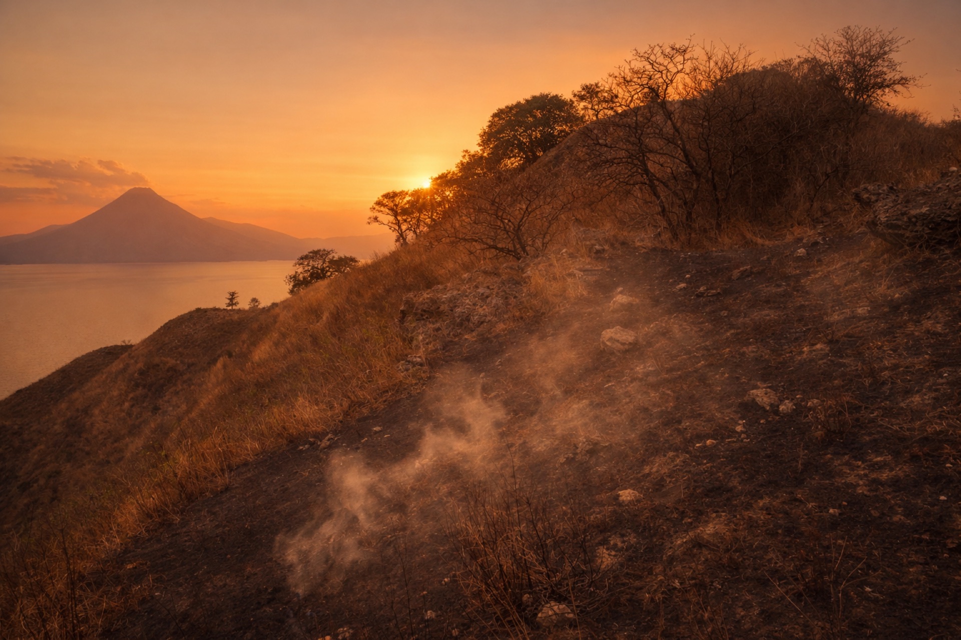 A brigade member working amid smoke on the burned mountainside